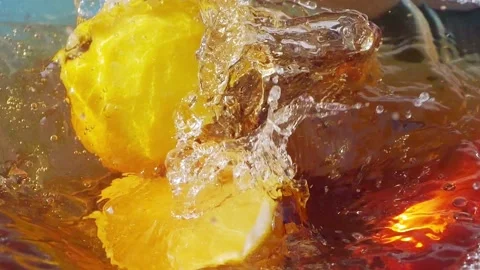 Lemon slices falling and splashing into iced tea, creating refreshing ripples Video stock 287696153