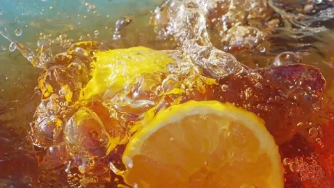Lemon slices falling and splashing into iced tea Stock Footage 287697143