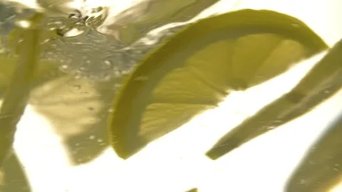 Lemon slices floating on water HD slow motion close up video. Fruit rotation Stock Footage 83932324