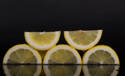 Lemon slices with reflection, black background, isolated, juicy lemons reflec Stock Photos