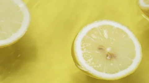 Lemon slices splashing on yellow background. Freshness and hydration. Pabulum. Stock Footage 284064809