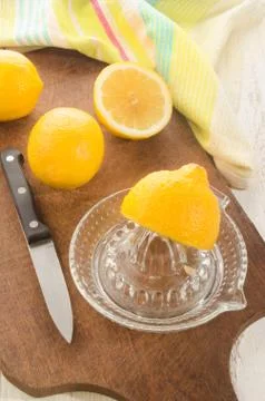 Lemon is squeezed on a lemon squeezer Stock Photos