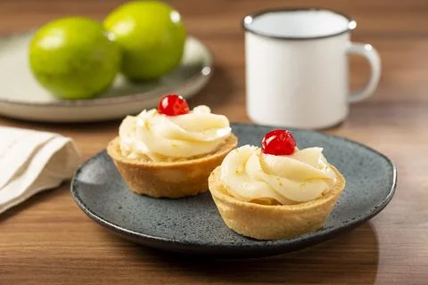 Lemon tartlets decorated with cherry. Stock Photos