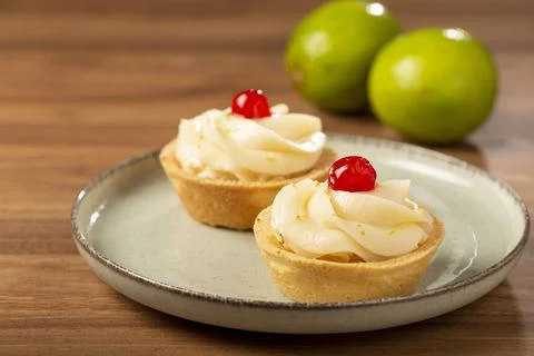 Lemon tartlets decorated with cherry. Stock Photos