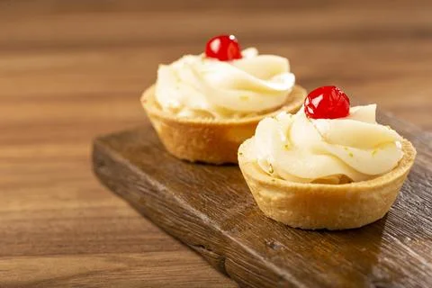 Lemon tartlets decorated with cherry. Stock Photos