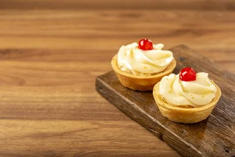 Lemon tartlets decorated with cherry. Stock Photos