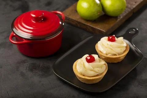 Lemon tartlets decorated with cherry. Stock Photos