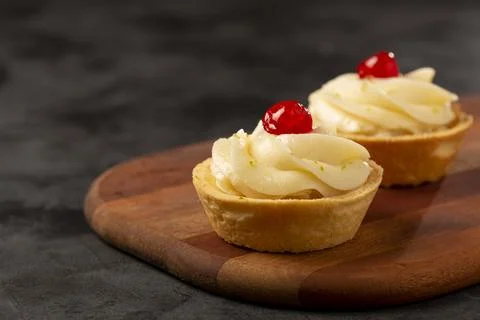 Lemon tartlets decorated with cherry. Stock Photos