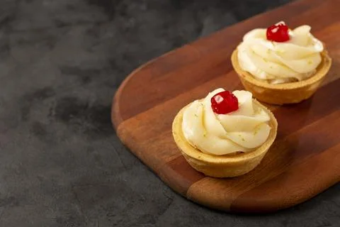 Lemon tartlets decorated with cherry. Stock Photos