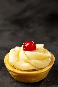 Lemon tartlets decorated with cherry. Stock Photos