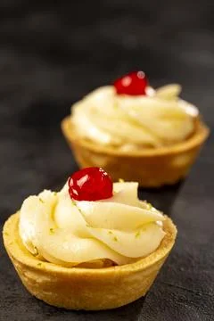 Lemon tartlets decorated with cherry. Stock Photos