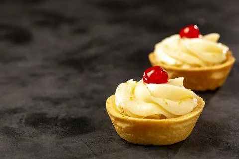 Lemon tartlets decorated with cherry. Stock Photos