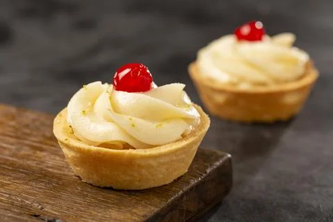 Lemon tartlets decorated with cherry. Stock Photos