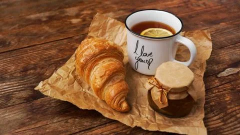 Lemon tea, home made jam, croissant on wooden table. Breakfast concept. Stock Photos