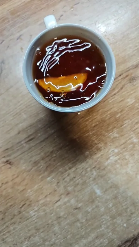 Lemon wedge dropping into steaming black tea, splashing Stock-Footage 307494132