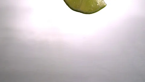 Lemon wedge falling into the water in slow motion Stock Footage 81228598