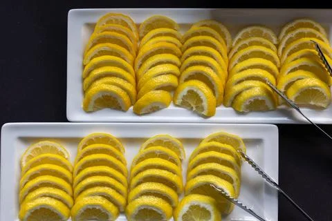 Lemon wedges arranged in rows on serving trays. 스톡 사진