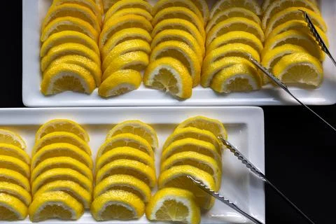 Lemon wedges arranged in rows on serving trays. Stock-Fotos