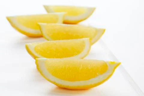 Lemon wedges on white background Stock Photos