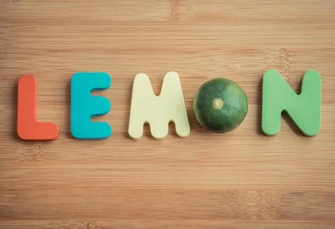Lemon wooden word on chopping block in vintage style Stock Photos