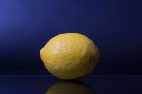 Lemon yellow on a blue background, studio photo, isolated Stock Photos