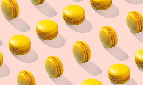 Lemon yellow macarons pattern on pink background isolated with hard shadows Stock Photos