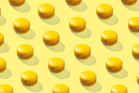 Lemon yellow macarons pattern on yellow background isolated with hard shadows 스톡 사진