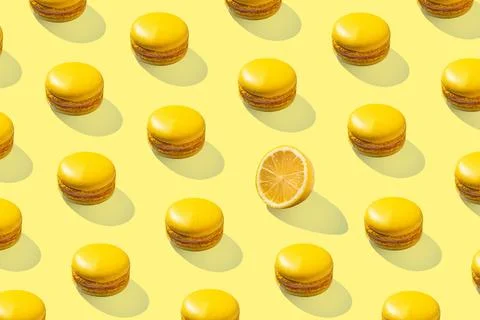 Lemon yellow macarons pattern on yellow background isolated with hard shadows 스톡 사진