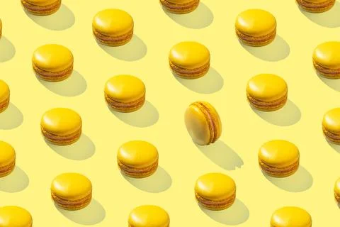 Lemon yellow macarons pattern on yellow background isolated with hard shadows 스톡 사진