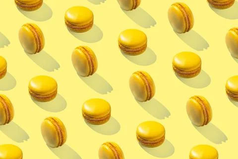 Lemon yellow macarons pattern on yellow background isolated with hard shadows 스톡 사진