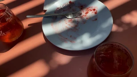 Lemonade and Empty Dessert Plate on Cafe Table After Cheesecake Stock Footage 343874211