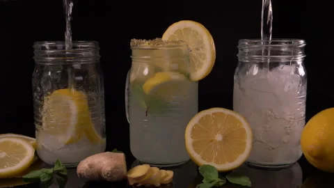 Lemonade being Poured in Jar with Ginger and Lemon Slices 4K Video stock 130997600