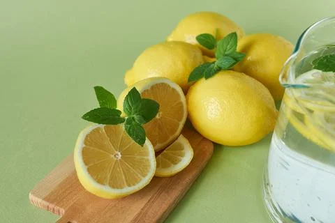 Lemonade with fresh lemons and mint on a green background Stock Photos