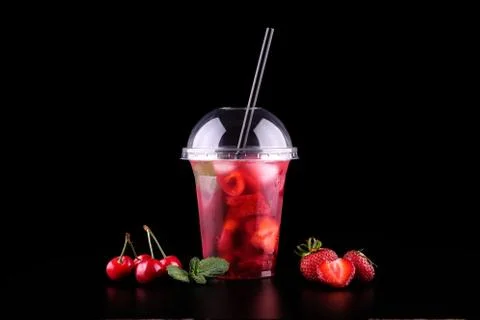 Lemonade to go cup with mint, cherry, strawberry on black background, isolate Foto stock