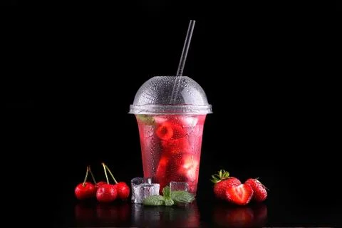 Lemonade to go cup with mint, cherry, strawberry on black background, isolate Stock Photos