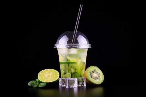 Lemonade to go cup with mint, lime and kiwi on black background, isolated Stock Photos