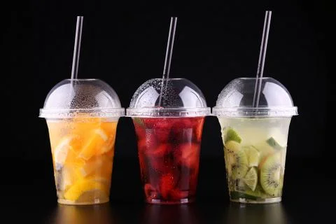 Lemonade to go. Three cups with mint, cherry, strawberry, kiwi, lime, orage, Stock Photos
