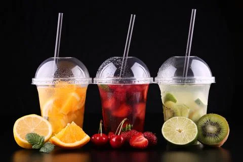 Lemonade to go. Three cups with mint, cherry, strawberry, kiwi, lime, orage, Stock Photos