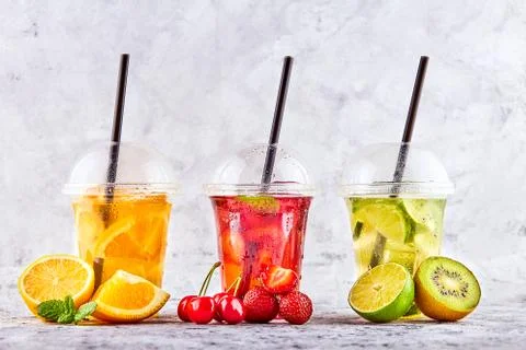 Lemonade to go. Three cups with mint, cherry, strawberry, kiwi, lime, orage, Foto stock