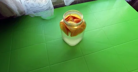 Lemonade from orange on a green table. Video stock 76688742