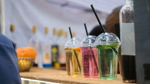 Lemonade in plastic glasses. green, red and yellow drinks on food market Stock Footage 162464800