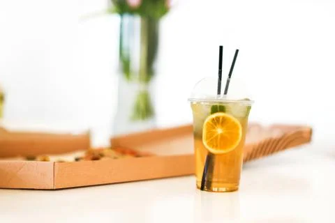 Lemonade in plastic to go cup next to pizza box Stock Photos