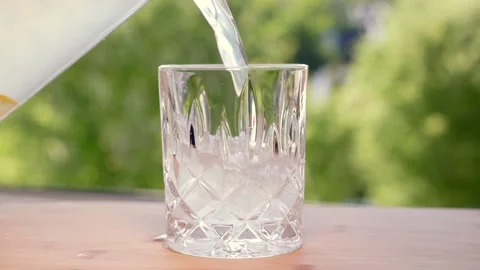 Lemonade is poured into a glass alongside a stack of sugar cubes Stock Footage 341345559