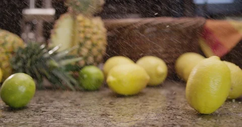 Lemons and limes rolling across countertop 1 Stock Footage 123847302
