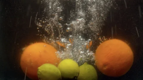 Lemons and oranges falling into the water with a splash Stock Footage 123704729