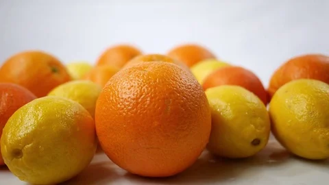 Lemons and Oranges spinning over white background Stock Footage 84168620