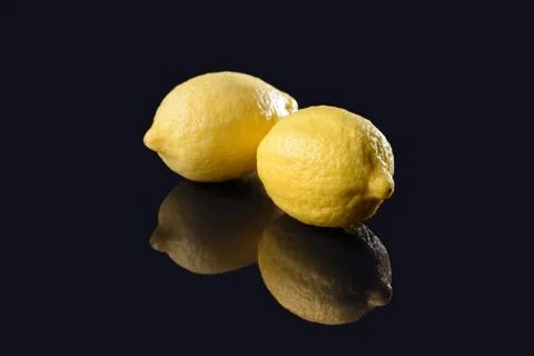 Lemons on black mirrored background Stock Photos