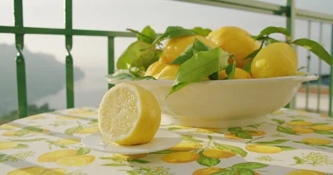 Lemons in a bowl on a table with a scenic backdrop during daylight. The vibrant Stock Footage 271148685