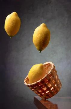 Lemons fall into a wicker basket Stock Photos