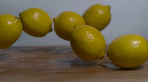 Lemons falling and bouncing in slow motion onto a cutting board Stock Footage 64677730